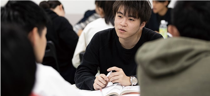 クラスメイトと勉学に励む学生