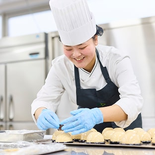 ケーキの飾り付けを行う学生