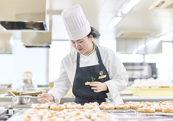 ケーキの飾り付けを行う学生